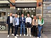 Seks personer står foran inngangen til Publicis-bygningen i en bygate.